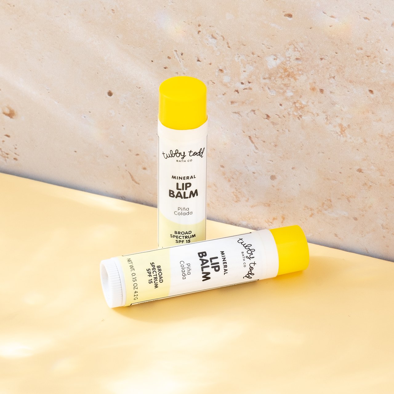 New Mineral Lip Balm Pina Colada 2 sets on the sandstone background